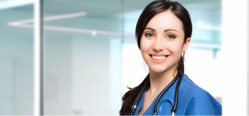 Smiling Brown Haired Nurse Looking at Camera